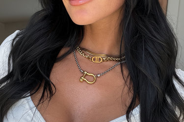 Woman wearing Pippa Mixed Metals Necklace layered with other gold chains.